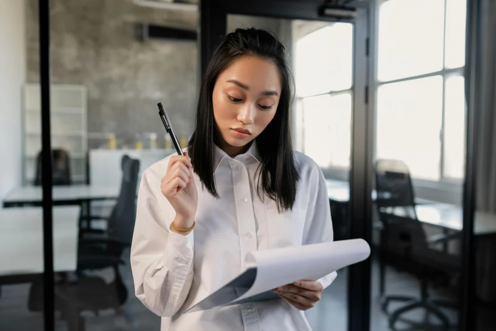 A woman thoughtfully reviews a document.