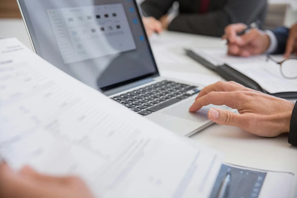Person focused on completing tasks on her laptop with a digital document open.