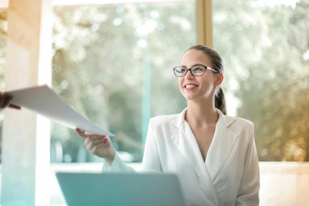 A young woman starting her first job, reviewing a document on her laptop.